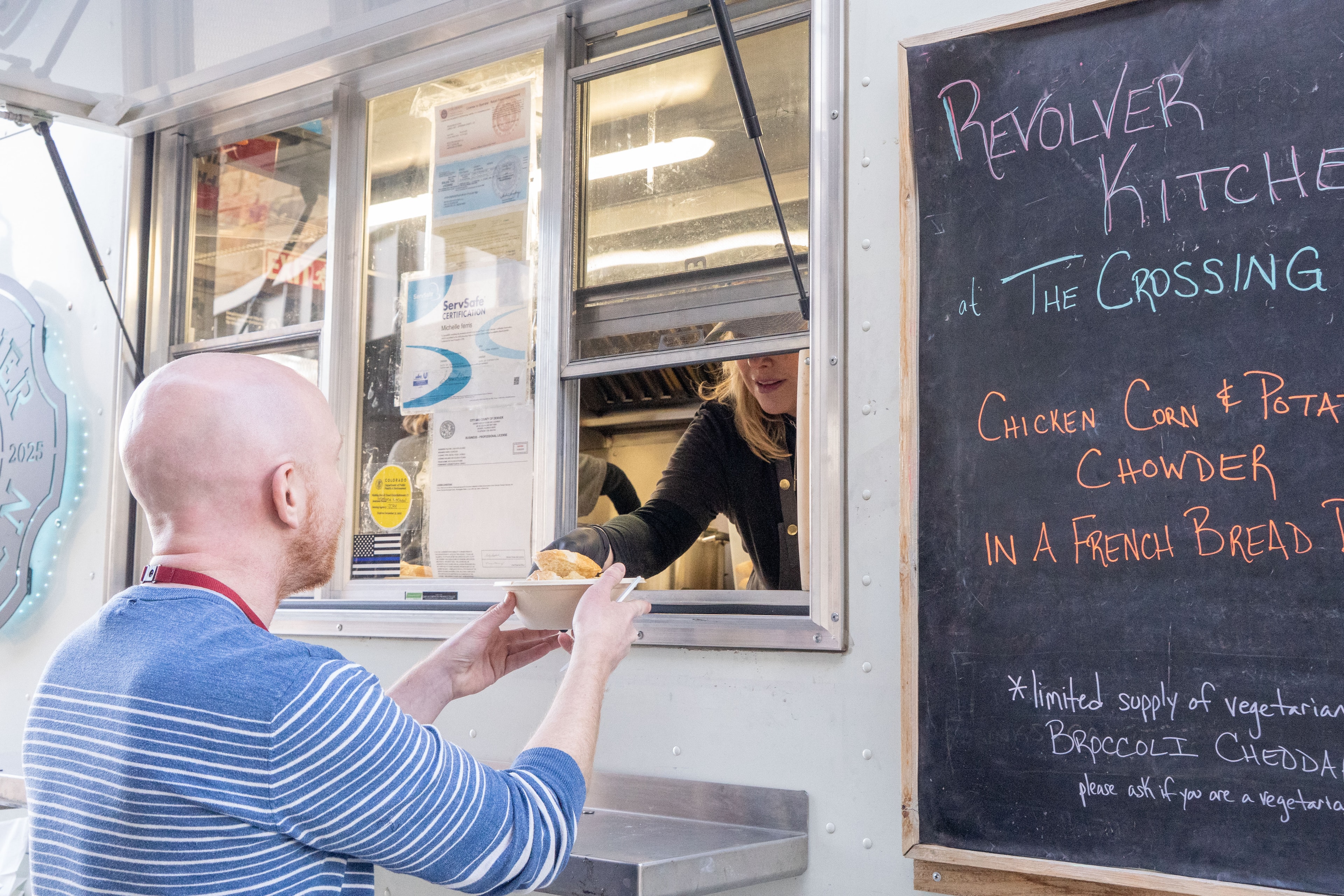 Customer receiving food at the Revolver Kitchen window