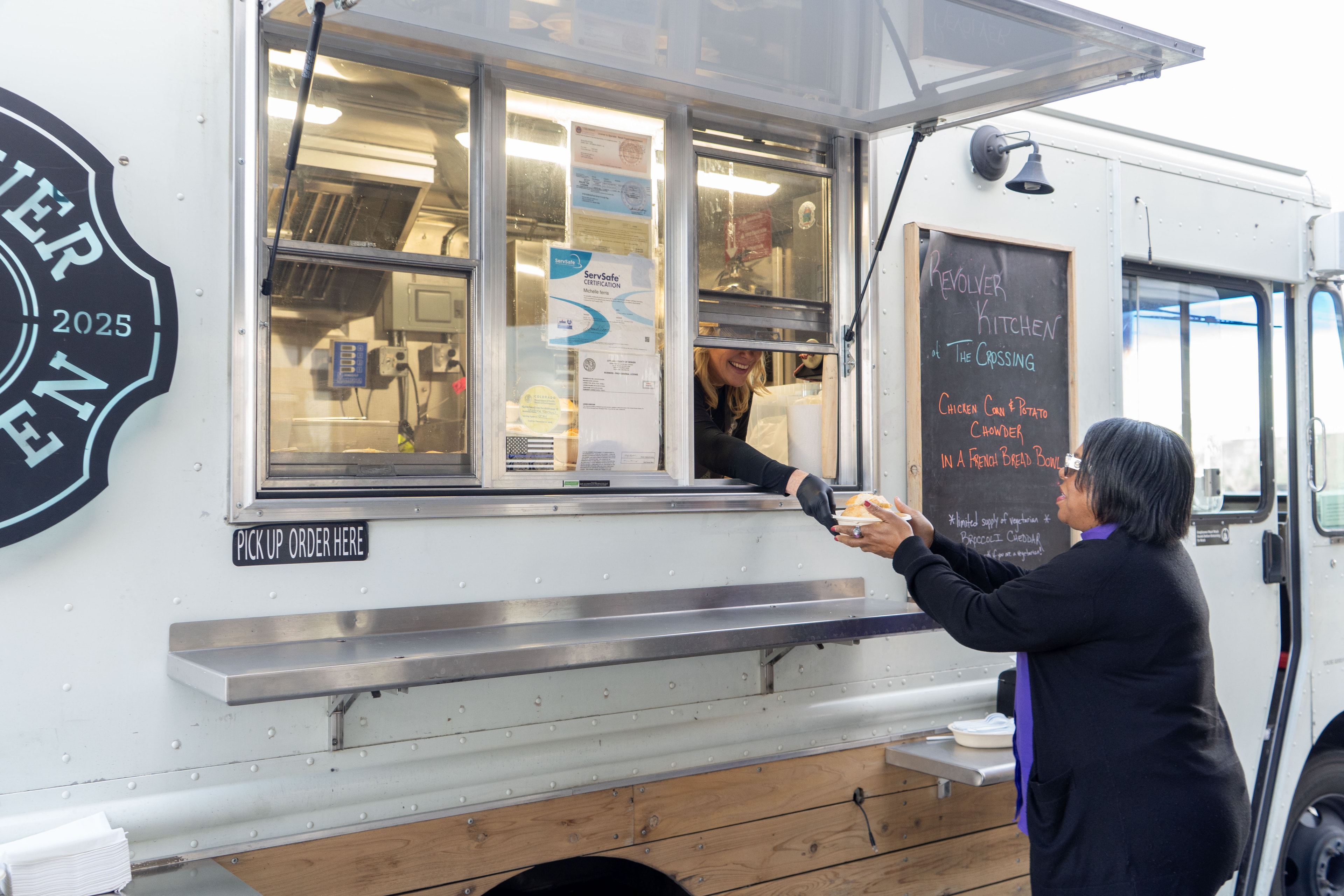 Customer ordering food at the Revolver Kitchen truck window